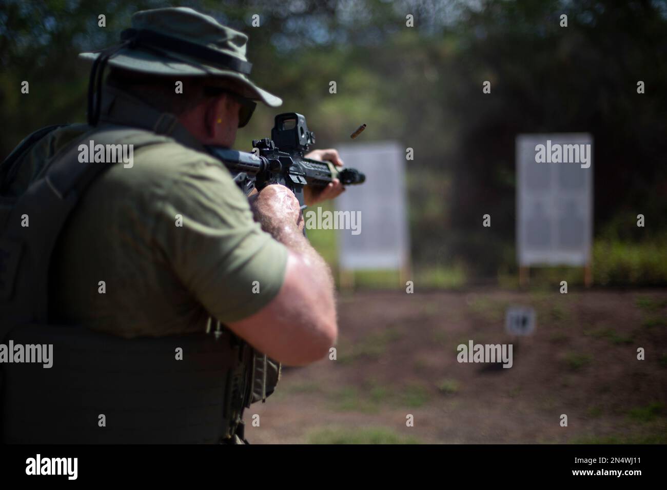 An officer with the Honolulu Police Department fires an M4 service carbine while conducting sustainment training at Pu’uloa Range Training Facility, Marine Corps Base Hawaii, Feb. 2, 2023. The training focused on utilizing patrol tactics in scenarios that simulate real-world situations. (U.S. Marine Corps photo by Lance Cpl. Terry Stennett III) Stock Photo