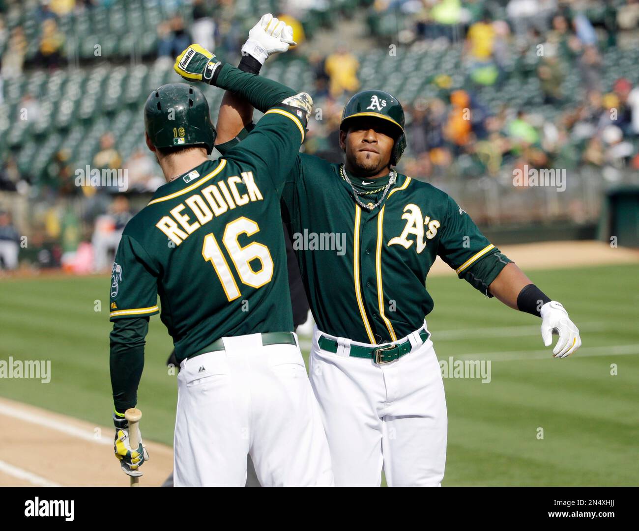 Oakland Athletics' Yoenis Cespedes, right, celebrates his solo home run  with teammate Josh Reddick (16) during the fourth inning of the second game  of a doubleheader baseball game against the Seattle Mariners