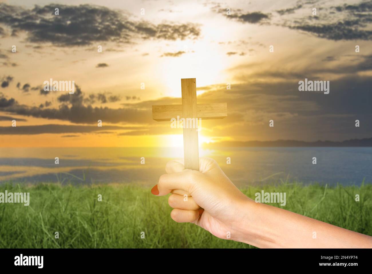 Human hand holding Christian cross with sunset sky background Stock ...
