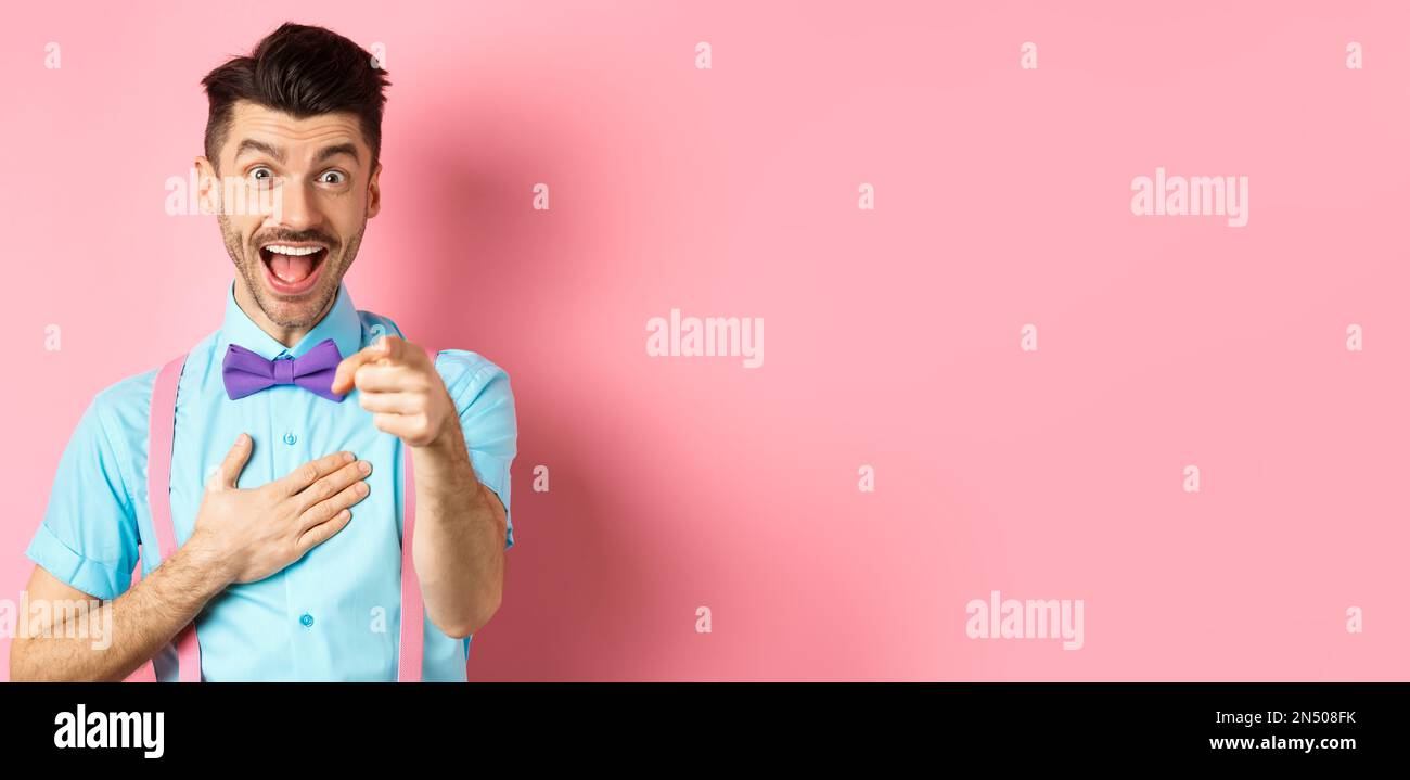 Funny guy laughing at something hilarious, smiling amazed and pointing