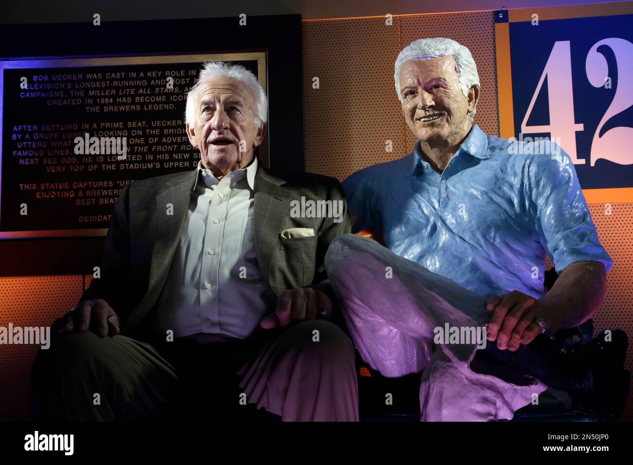 Milwaukee Brewers radio announcer Bob Uecker sits next to his statue  Friday, April 25, 2014, at Miller Park in Milwaukee. The statue of the Hall  of Fame broadcaster was unveiled before the