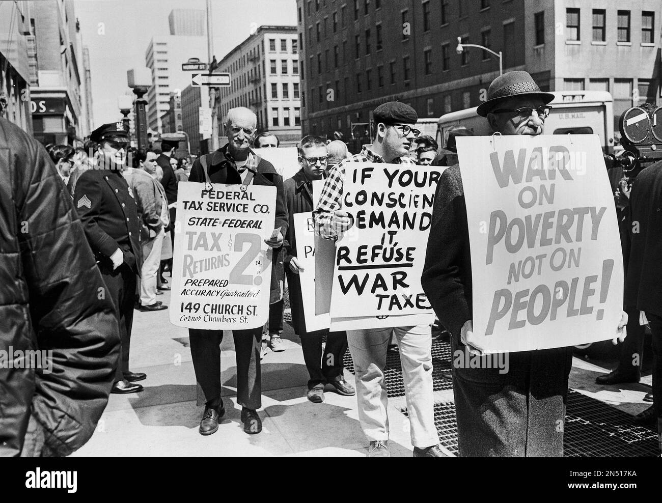 A sandwich man advertising a tax help service, marches past pickets
