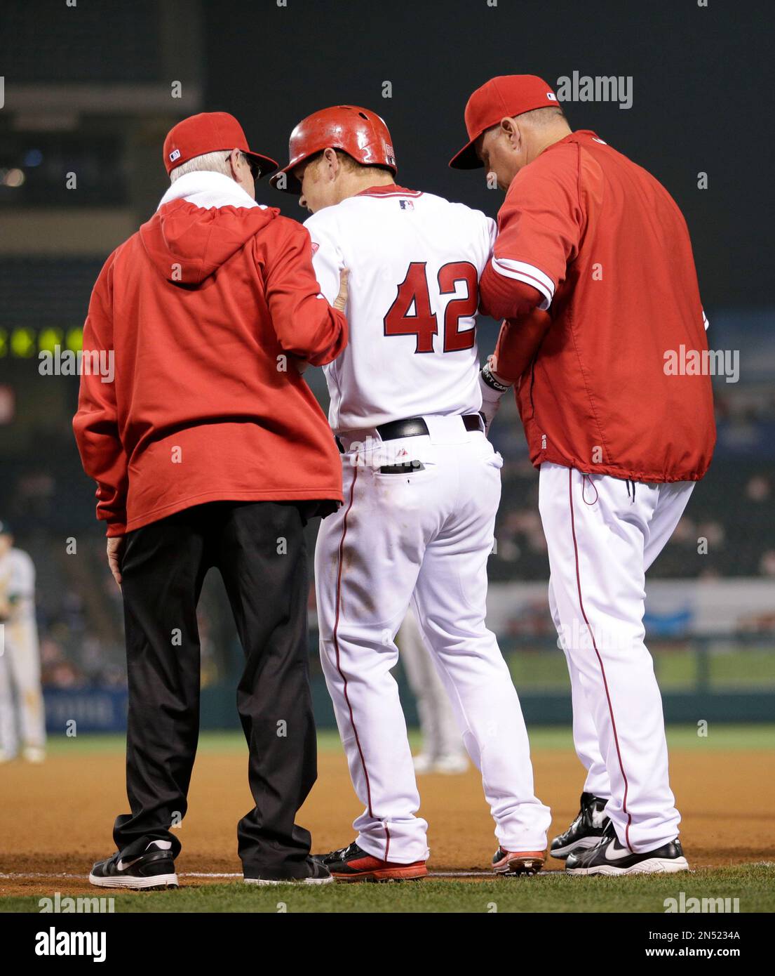 Los Angeles Angels' Kole Calhoun, center, is helped off the field