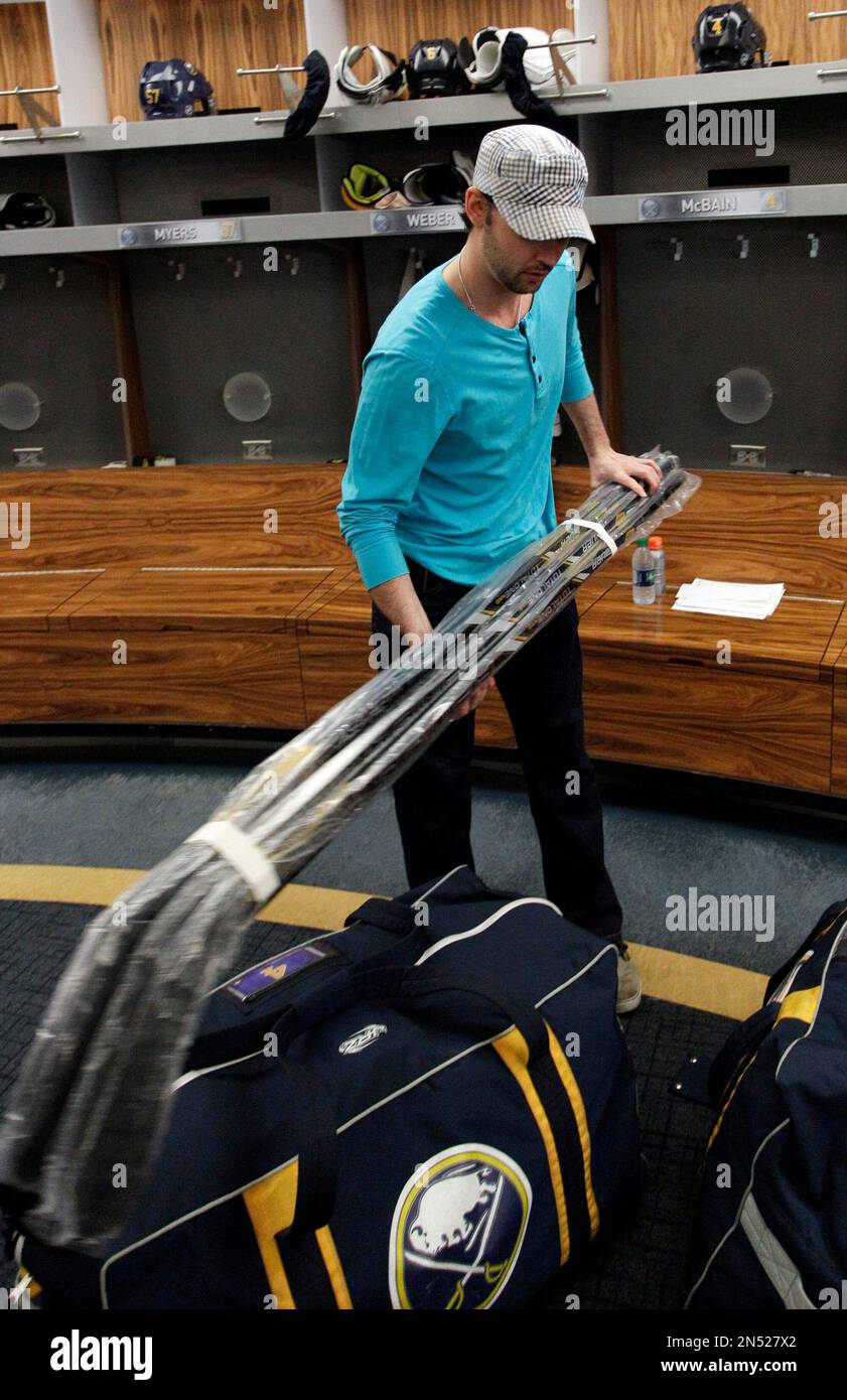Buffalo Sabres defenseman Jamie McBain removes his sticks from his