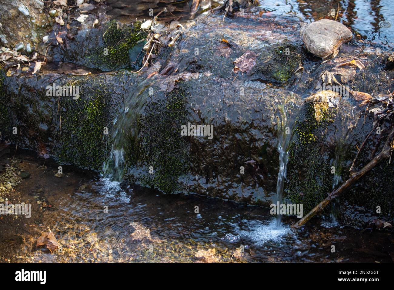 Little stream flowing over rocks into a little pool of water with