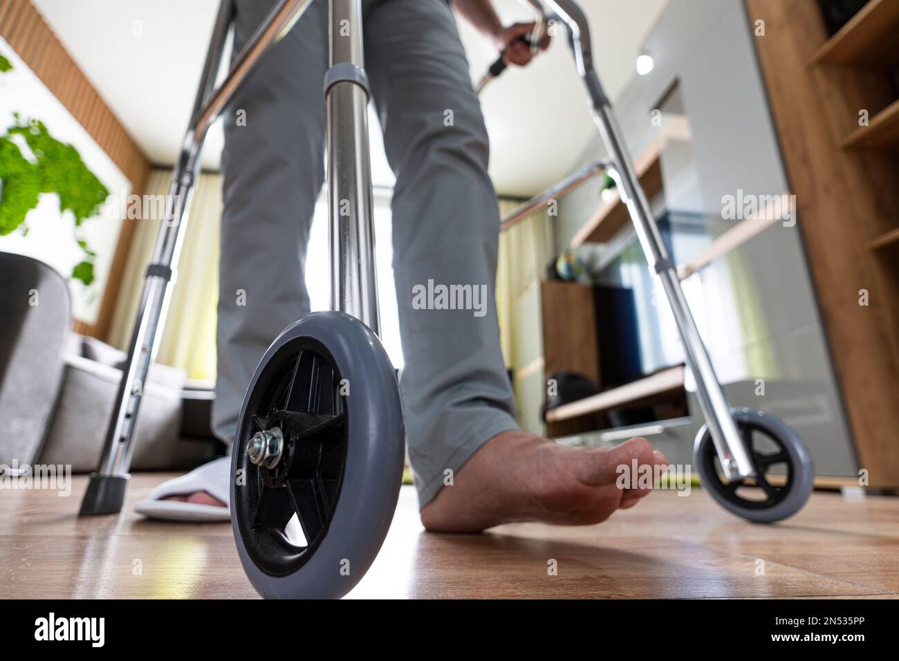 a sick person walks with the help of special devices for rehabilitation