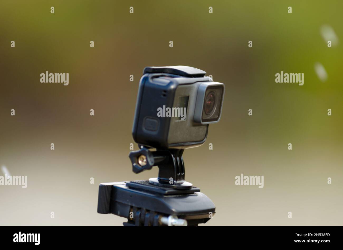 Action camera is recording video on a blurred background of snow and grass with a river. Stock Photo