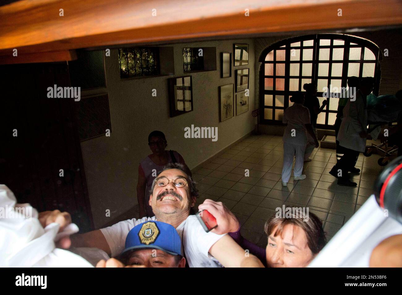 Gonzalo Garcia, the son of Gabriel Garcia Marquez, prevents photographers  from taking picturesusing a sheet as his father arrives home from the  hospital in Mexico City, Tuesday, April 8, 2014. A medical, image size:1300x956
