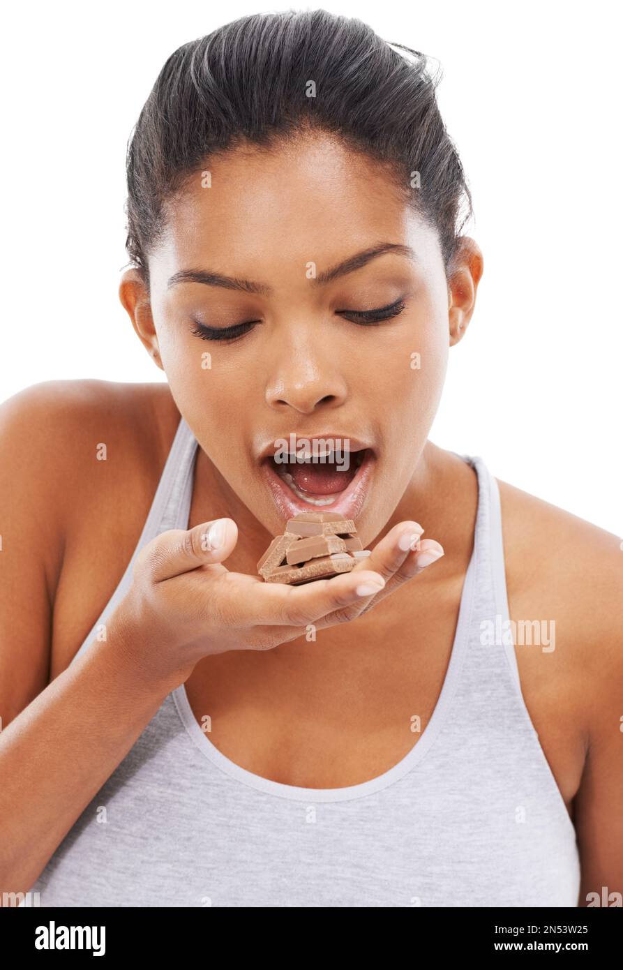 Indulging in her cravings. A gorgeous young woman in sportswear eating chocolate. Stock Photo