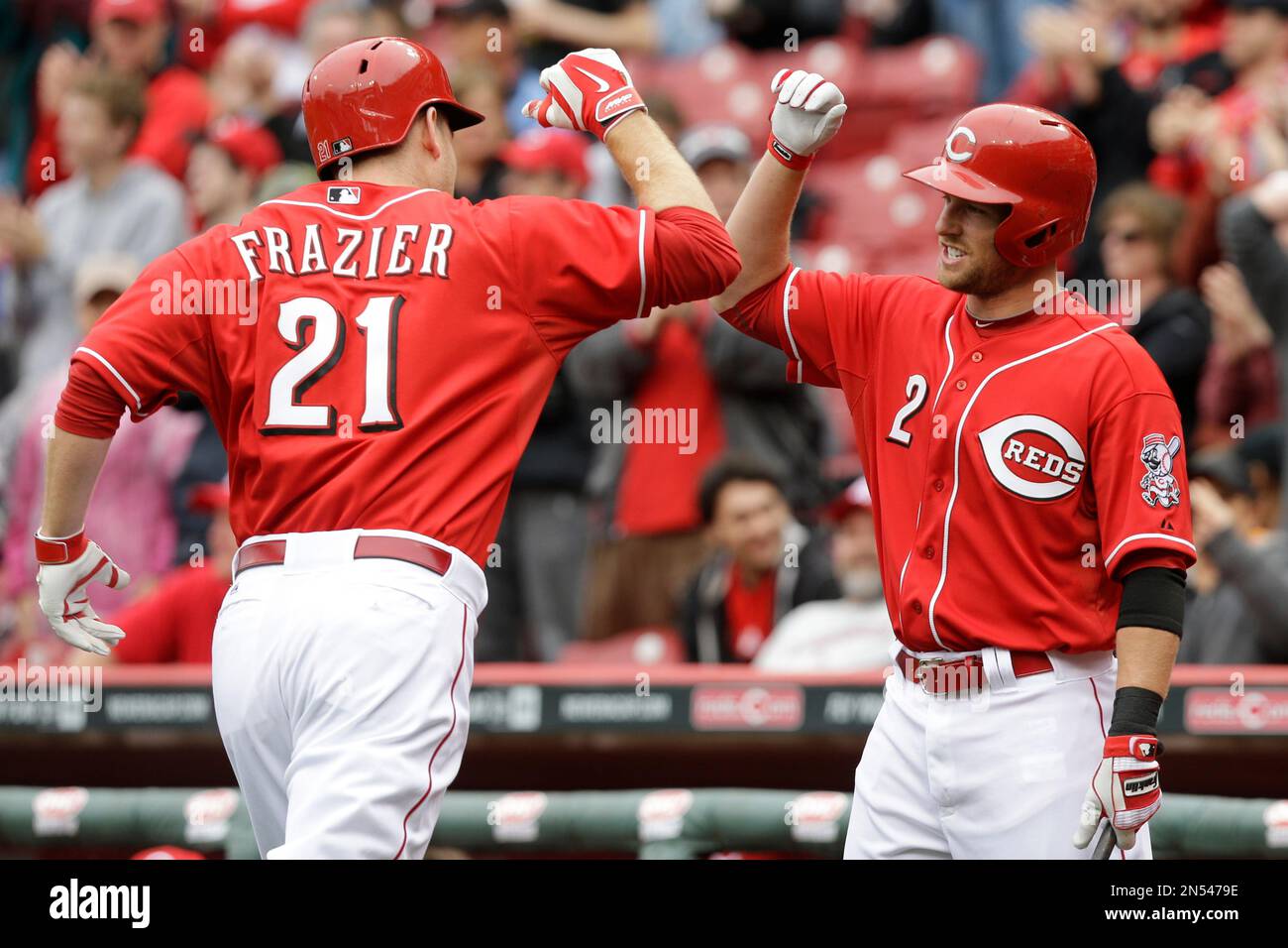 Cincinnati Reds' Todd Frazier (21) is congratulated by Zack Cozart (2)  after Frazier hit a solo home run off St. Louis Cardinals starting pitcher  Lance Lynn in the first inning of a