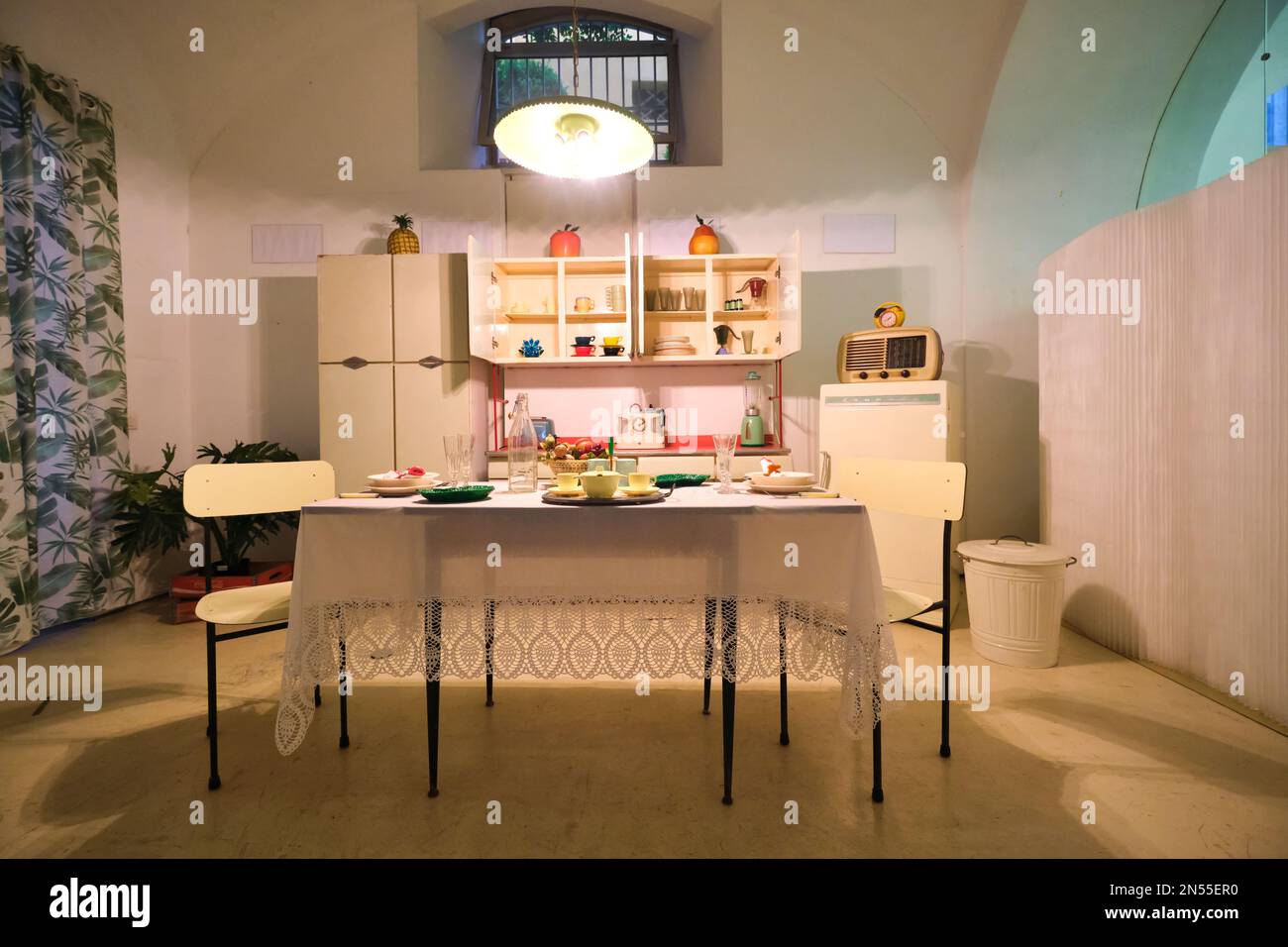 A display of a vintage kitchen, full of plastic dishes, appliances