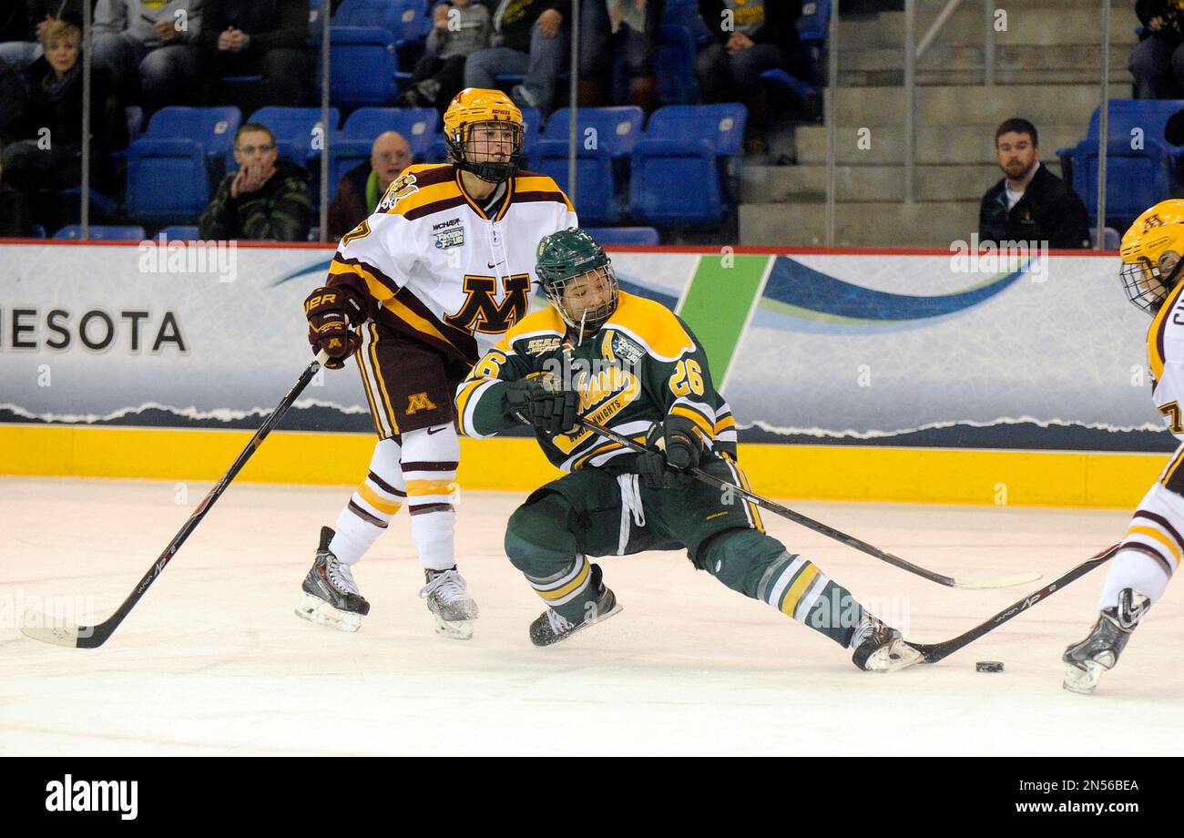 Clarkson's Jamie Lee Rattray, center, fights for a puck with Minnesota's  Rachael Bona, left, and Baylee Gillanders in the third period of an NCAA  college hockey game in the finals of the