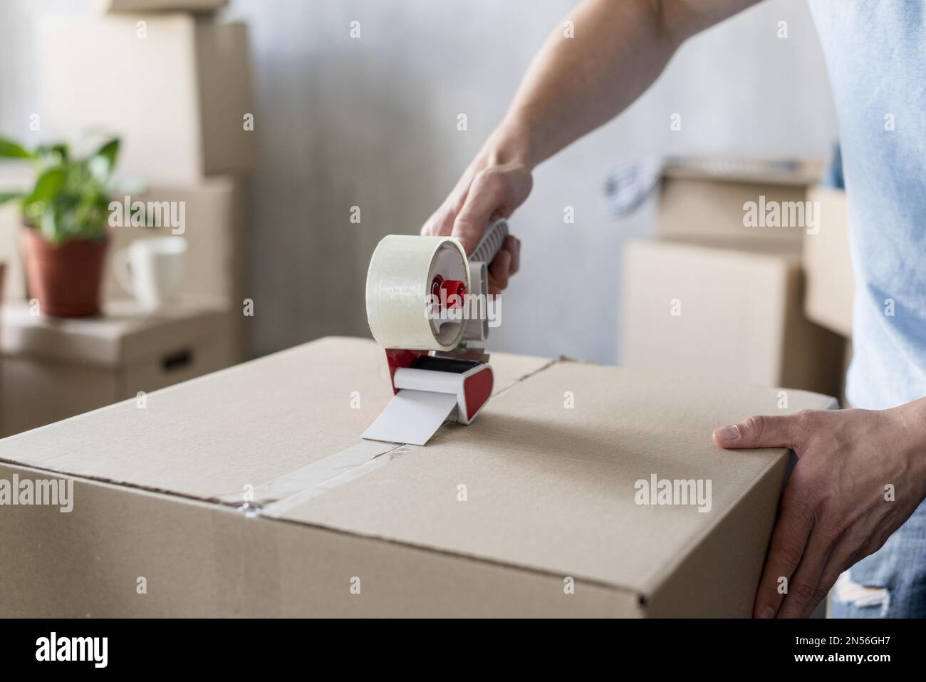 man using scotch tape box ready moving out . Resolution and high