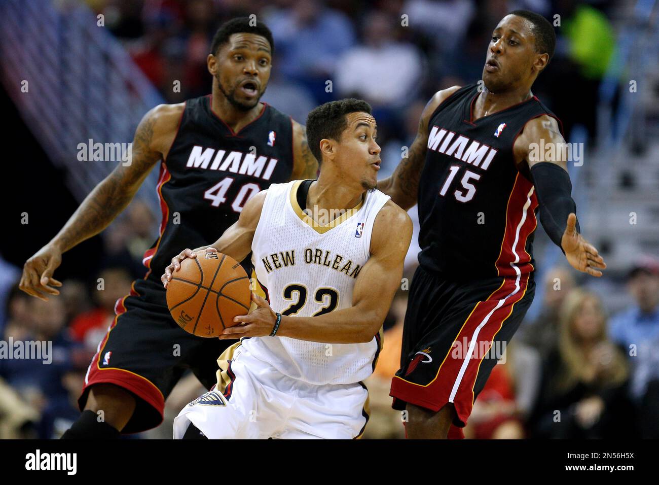 New Orleans Pelicans guard Brian Roberts (22) drives against Miami Heat  guard Mario Chalmers (15) and Miami Heat forward Udonis Haslem (40) during  the first half of an NBA basketball game in