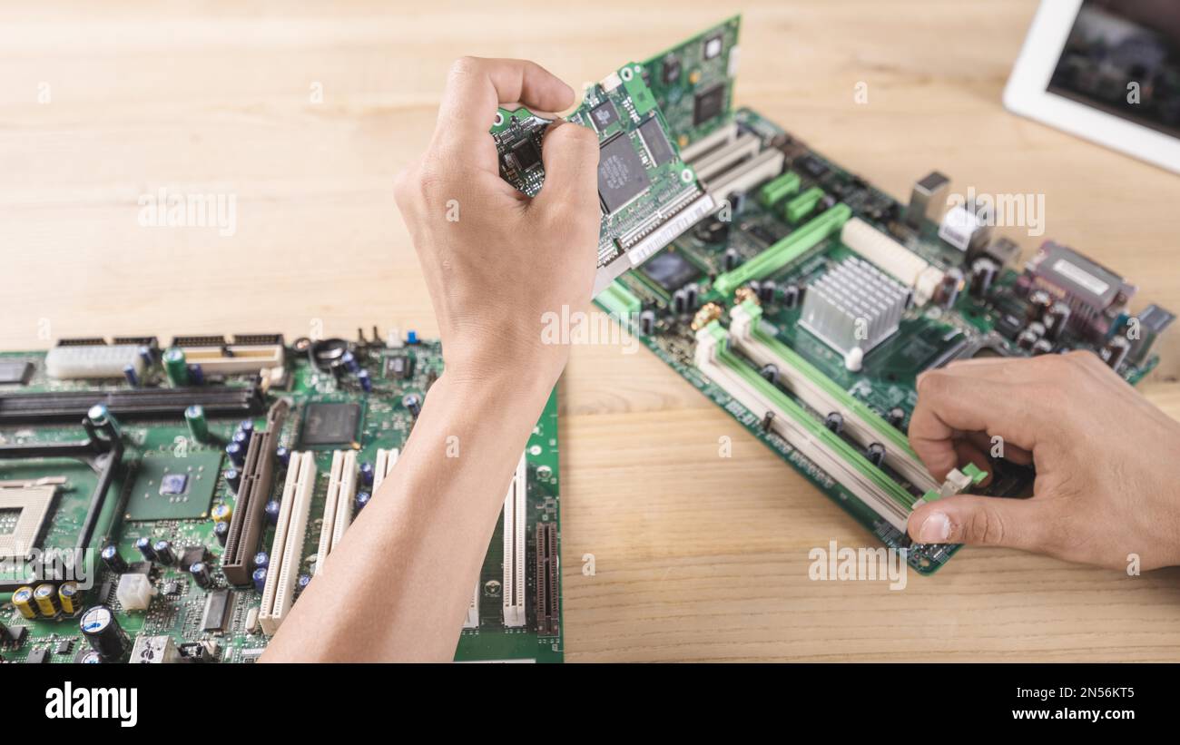 male hardware engineer inserting circuit board memory slot . Resolution and high quality beautiful photo Stock Photo