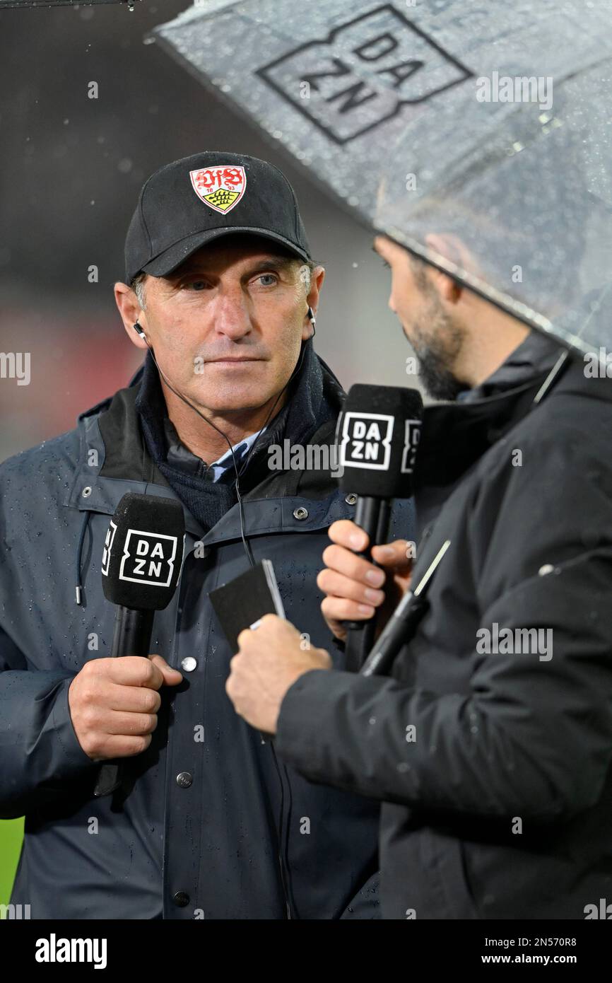 Sports presenter reporter Daniel Herzog, DAZN, in interview with microphone logo with coach coach Bruno Labbadia VfB Stuttgart rain, umbrella Stock Photo