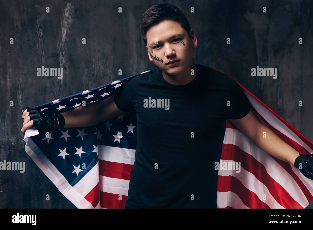 Tattooed guy with US flag on dark background Stock Photo