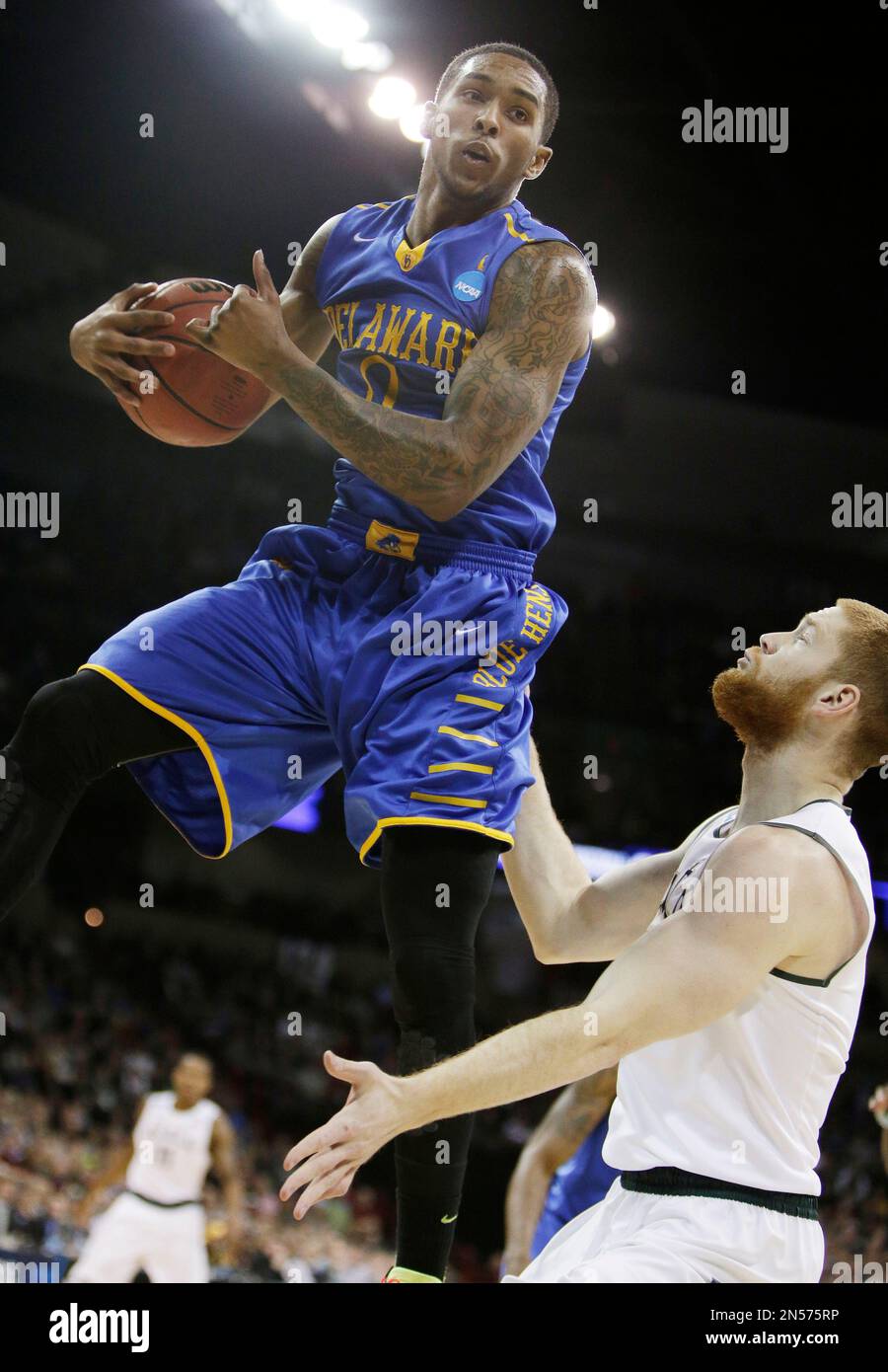 Delaware’s Davon Usher, left, grabs a rebound against Michigan State’s