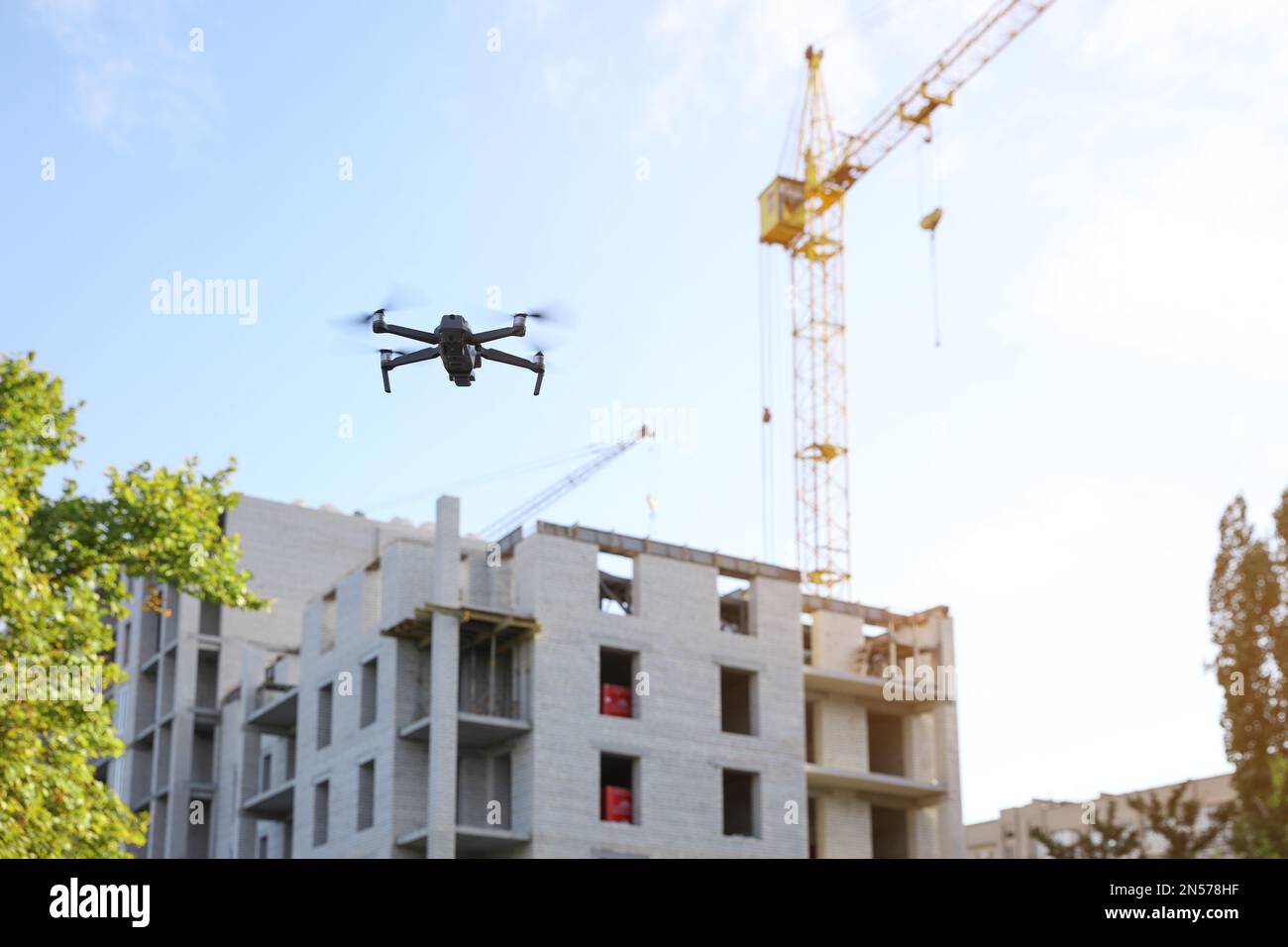 Building Rflying Modern drone flying at building site. Aerial photography Stock Photo ...