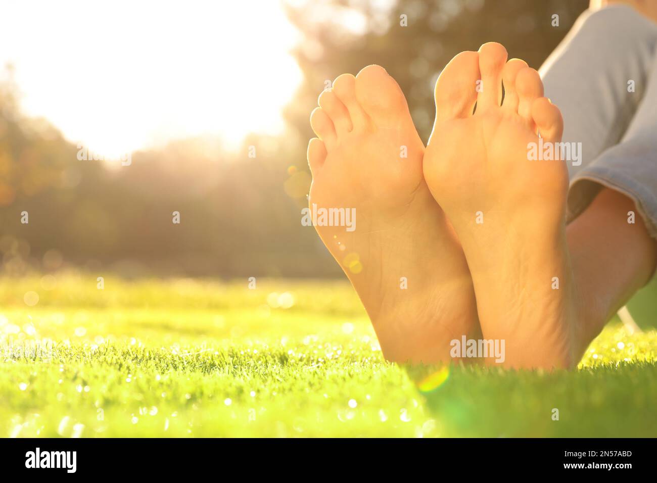 Woman sitting on grass barefoot hi-res stock photography and images - Alamy