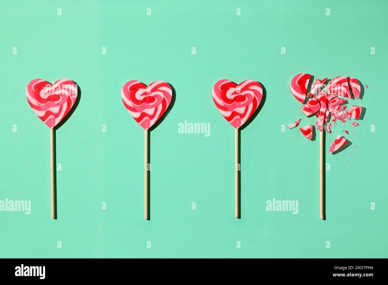 A Line Formation Lollipop In Shape Of Heart and Last One Broken Stock Photo