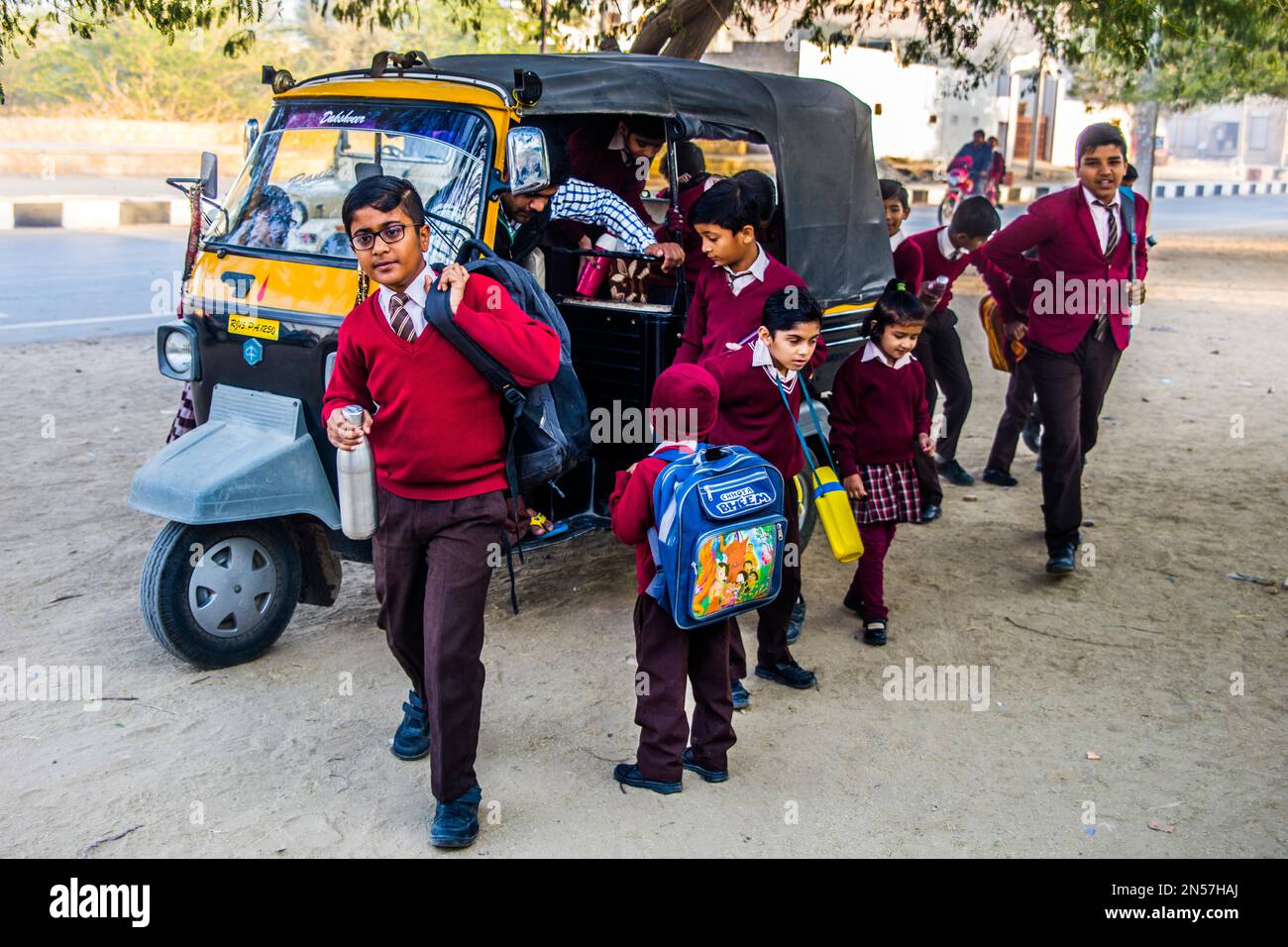 Students getting out of the tuk-tuk, St. Georges School in Rajasthan, Jaisalmer, Rajasthan, India Stock Photo