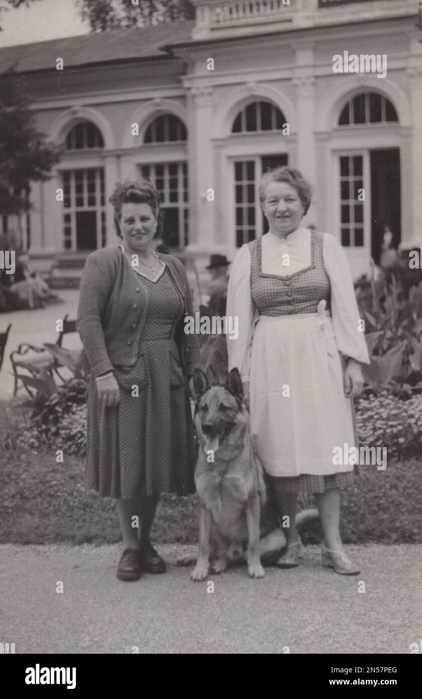 Vintage Photograph about pet dogs : two ladies with German Speherd dog.  Loyal, confident, courageous, and steady, the German Shepherd is truly a dog lover's delight. Stock Photo