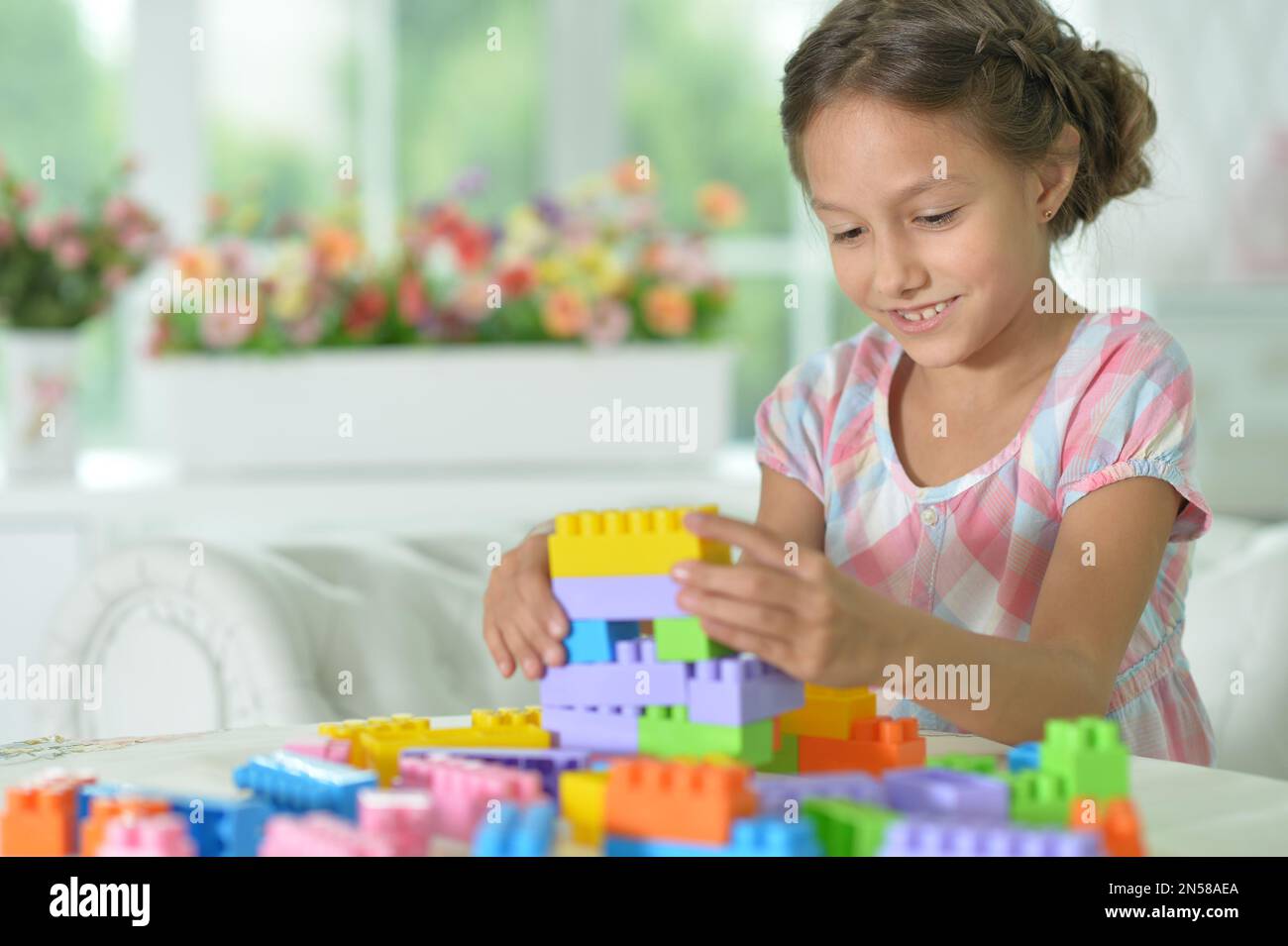 little girl playing with colorful plastic blocks Stock Photo - Alamy