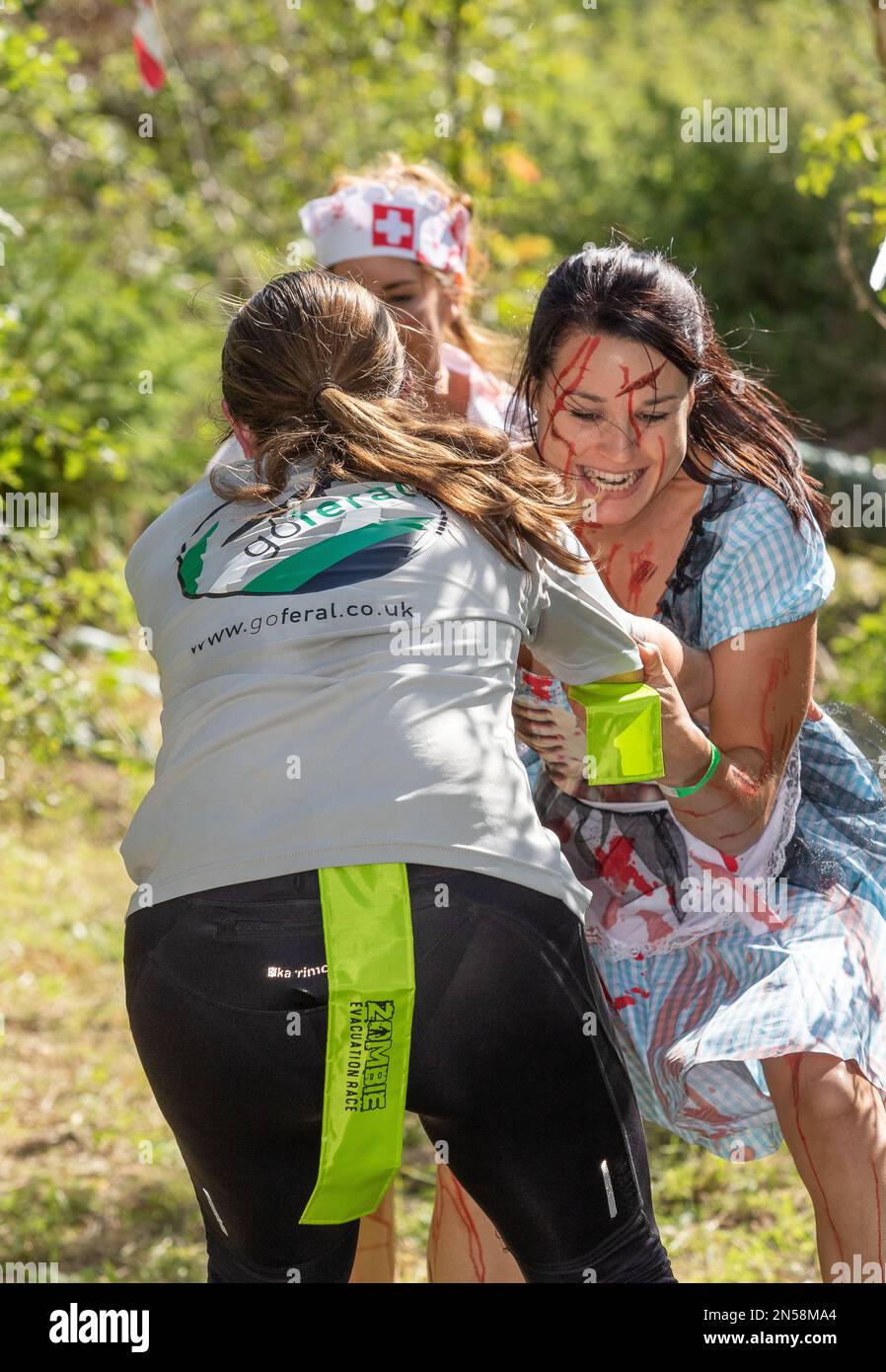 A zombie nurse and a girl next door try to grab the lime green streamer from a passing woman runner at a Zombie Evacuation event in Norfolk ... NFN Stock Photo