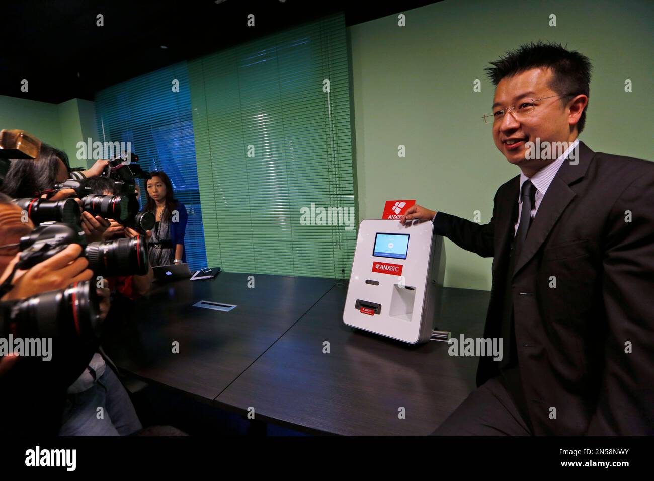Ken Lo, CEO of ANXBTC Bitcoin Exchange poses with his Bitcoin ATM during a  launch event in Hong Kong Thursday, March 13, 2014. The Bitcoin Exchange  unveils the first Hong Kong Bitcoin