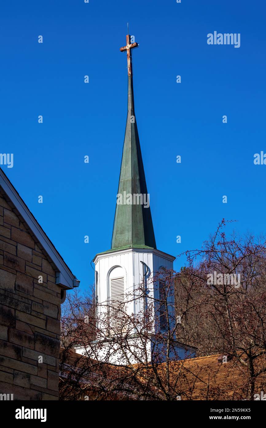 St. Joseph's Catholic Church steeple with a Pax Christi symbol on it and a cross at the top on a spring day in Taylors Falls, Minnesota USA. Stock Photo