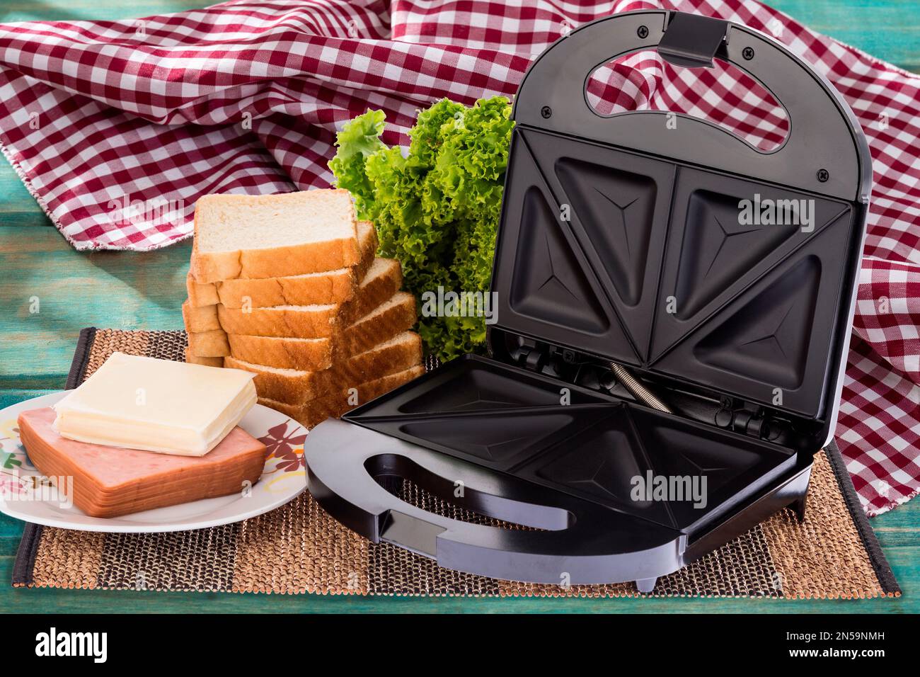 https://c8.alamy.com/comp/2N59NMH/black-sandwich-maker-photo-on-wooden-background-2N59NMH.jpg