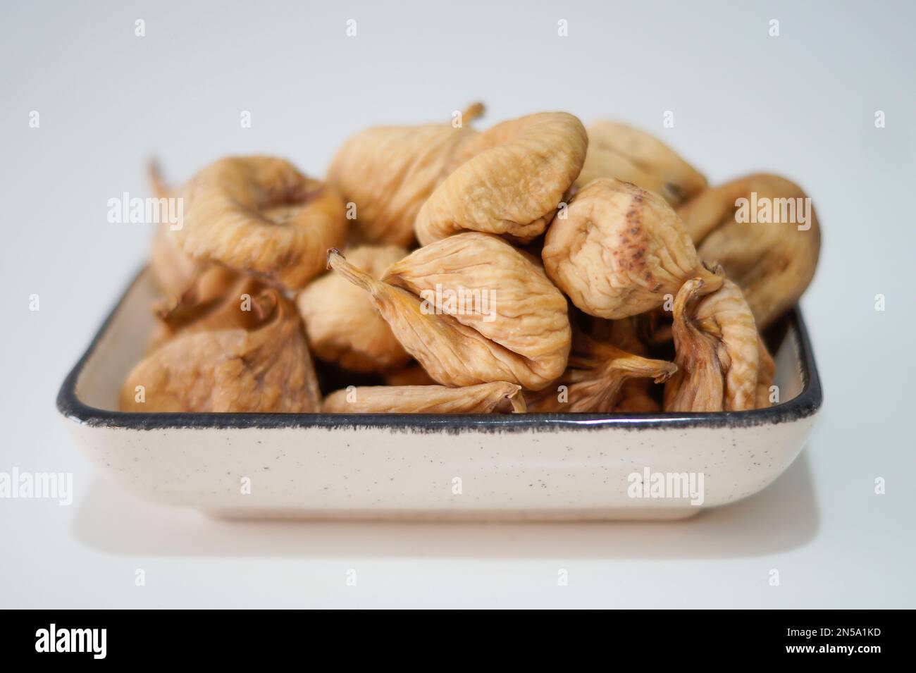 Dried figs in plate isolated on white Stock Photo