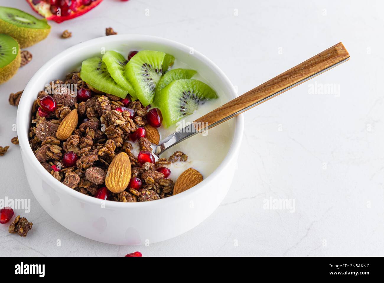 Bowl of chocolate oat granola with yogurt, fresh kiwi fruit