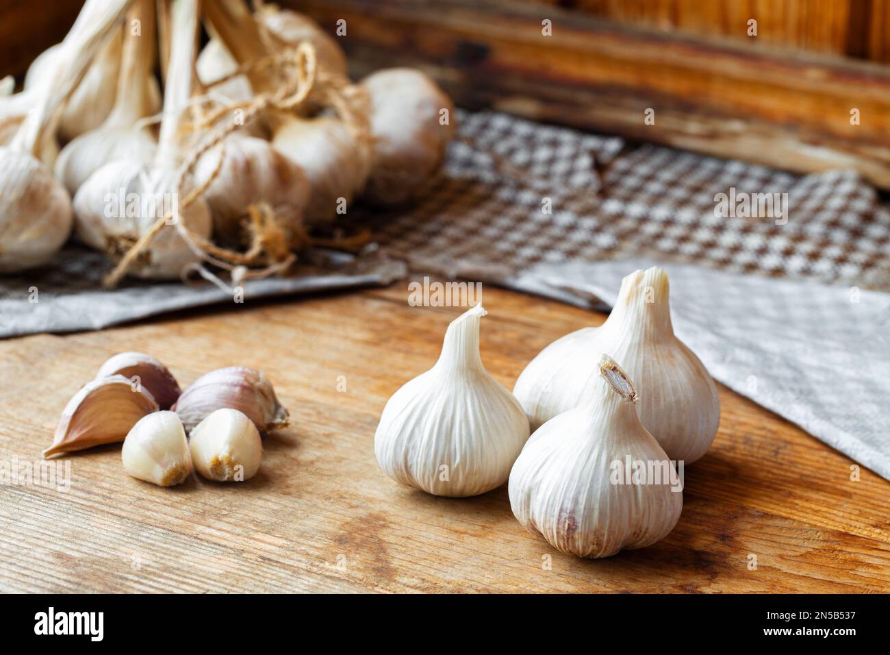 Fresh garlic bulbs and cloves on rustic wooden surface