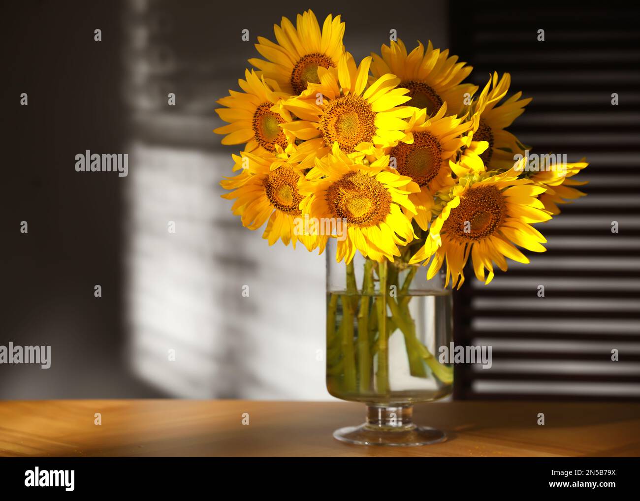 Vase with beautiful sunflower in wicker basket and bottle of orange juice  on wooden table Stock Photo - Alamy