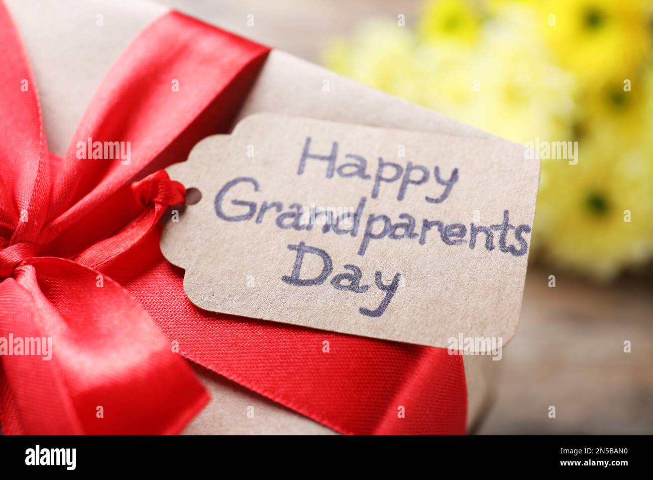 Beautiful gift box and tag with phrase Happy Grandparents Day on ...