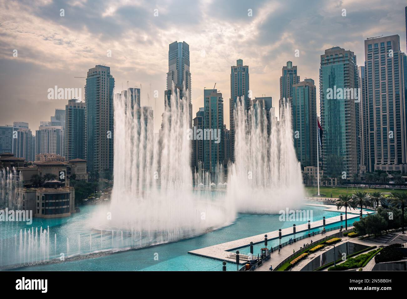 The Dubai Fountain, largest choreographed fountain system in the world. Fountain performing on a powerful beat matching the moody weather Stock Photo