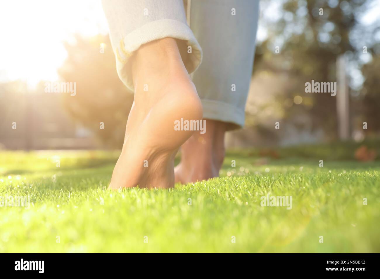 Man walking barefoot on fresh green grass, closeup Stock Photo