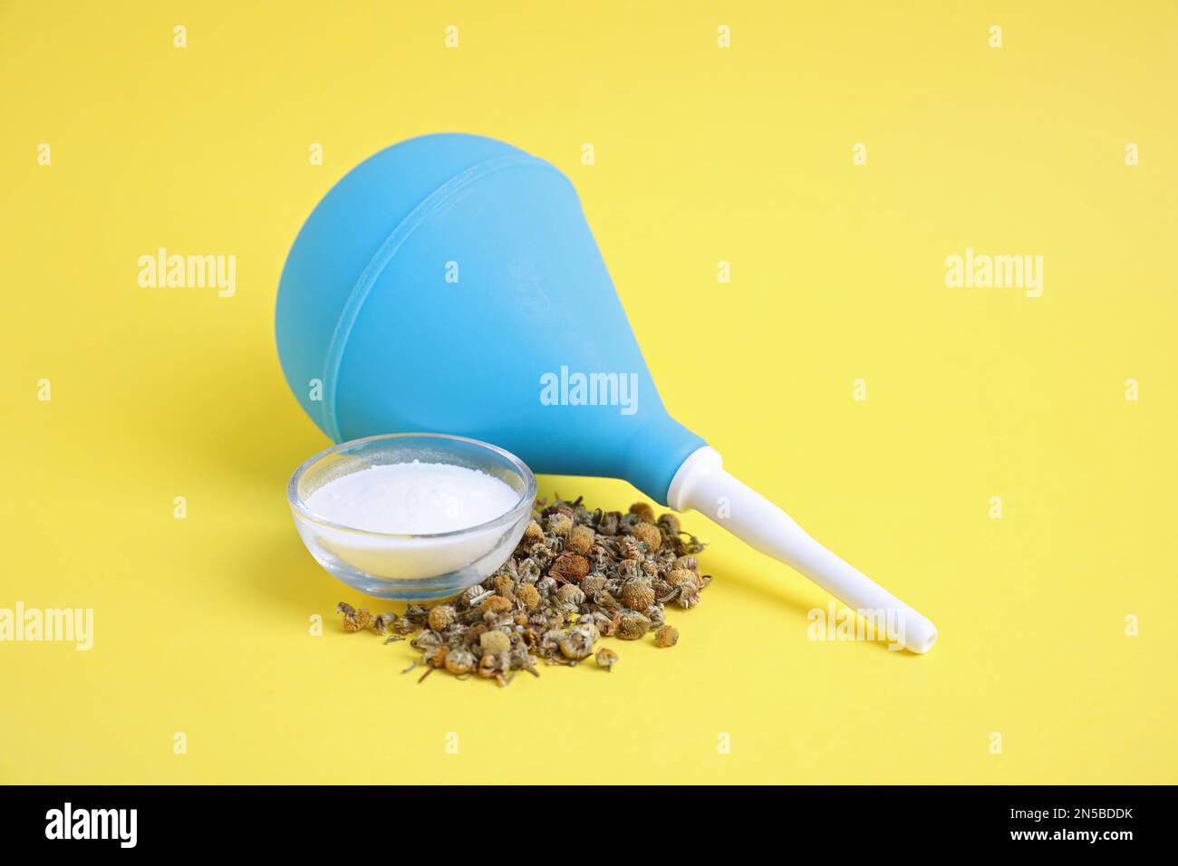 Blue enema, soda powder and dry chamomile flowers on yellow background  Stock Photo - Alamy