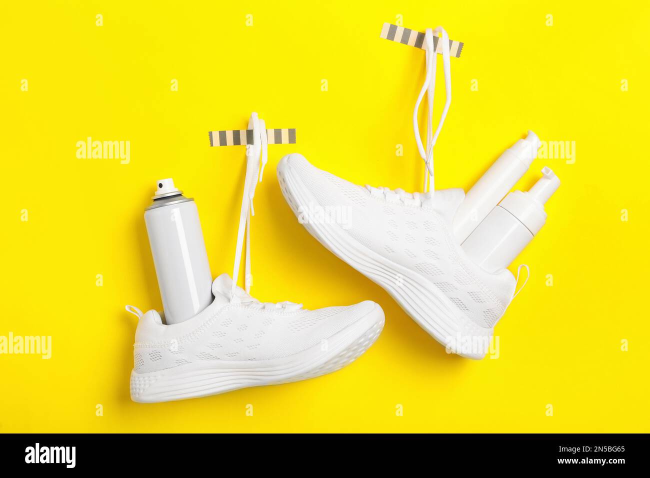 Stylish footwear with shoe care accessories hanging on yellow