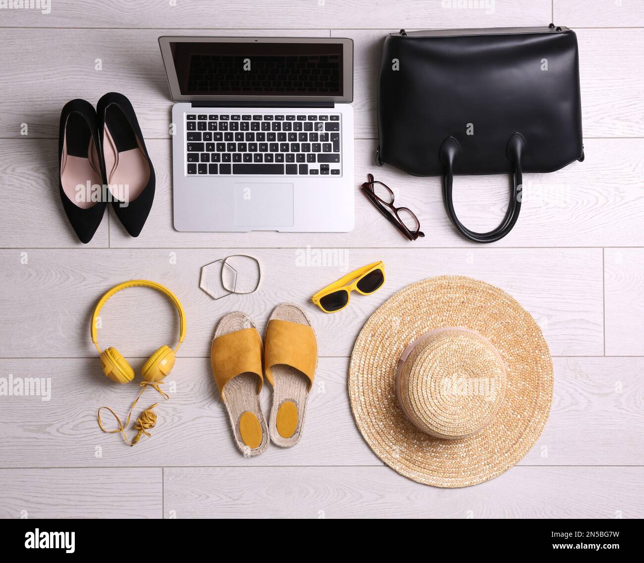 Flat lay composition with business supplies and beach accessories on white wooden floor. Concept of balance between work and life Stock Photo