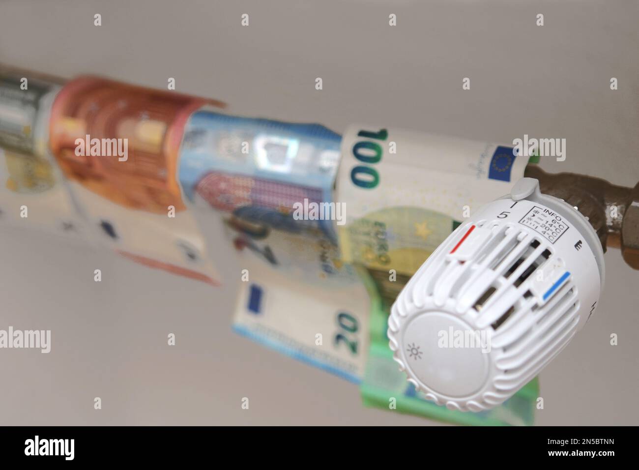 thermostat of heater on 5, Euro bills, heating allowance Stock Photo