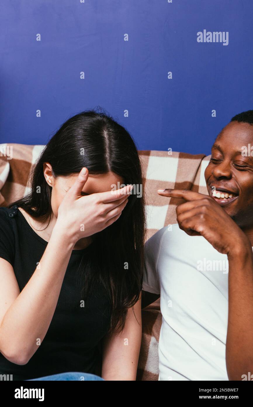 Man and woman on couch laugh out loud, funny jokes Stock Photo Alamy