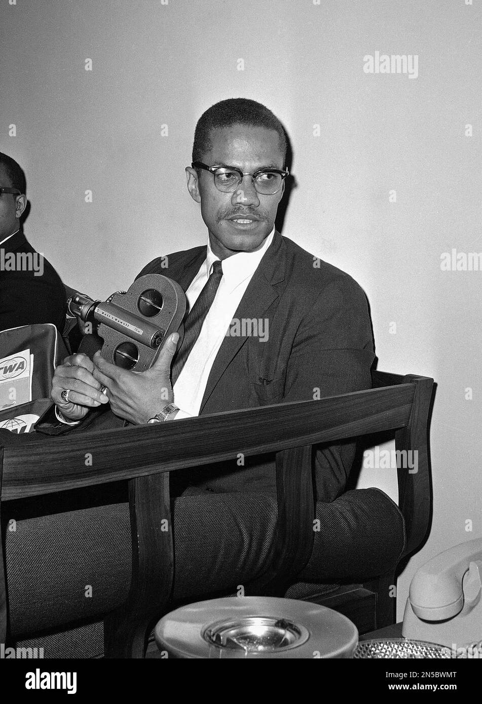 Malcolm X, civil rights activist and black Muslim leader, holds a movie(02)