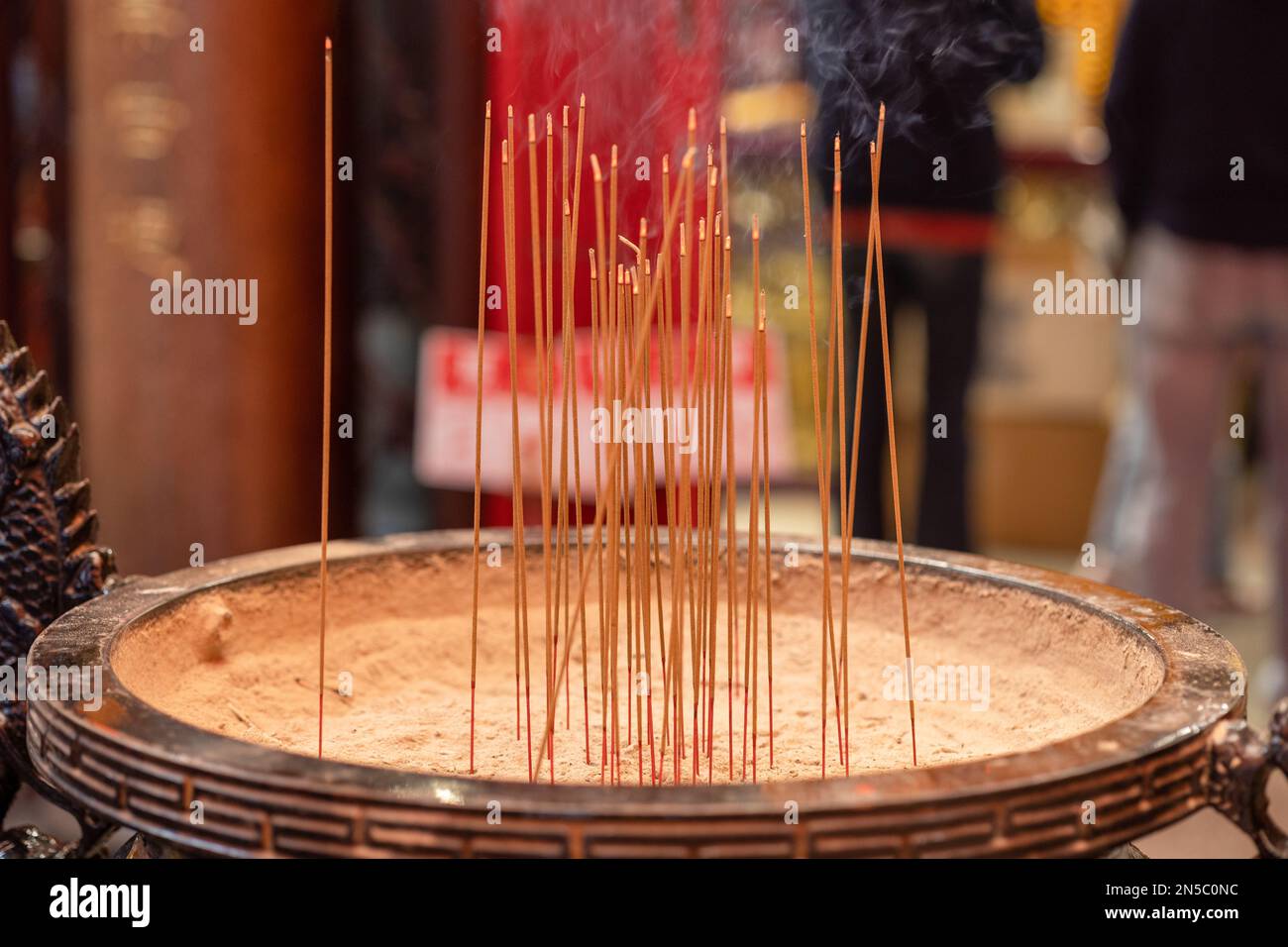 Incense burner with smoke and sticks of burning incense. Stock Photo