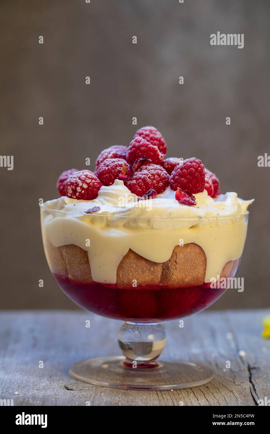 Raspberry trifle with fruit jelly, custard and cream Stock Photo