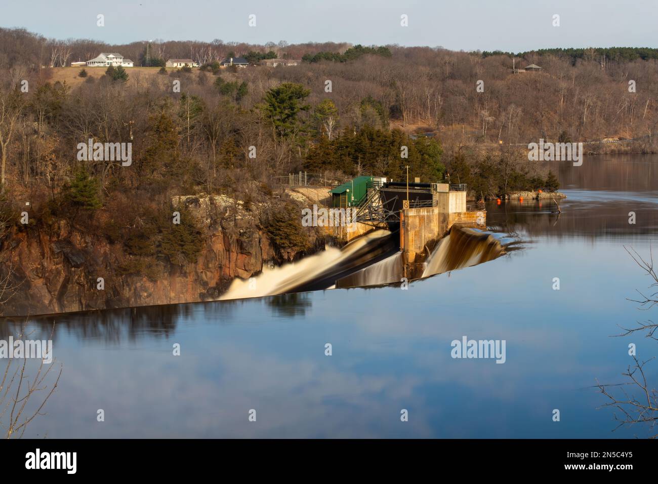 Hydroelectric dam with clouds reflected in the still, calm waters of