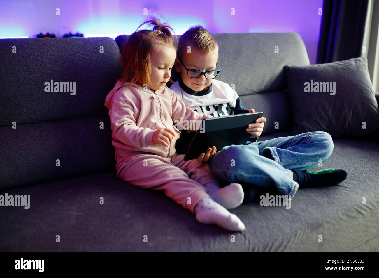 Danya's older brother teaches her younger sister how to use a tablet ...
