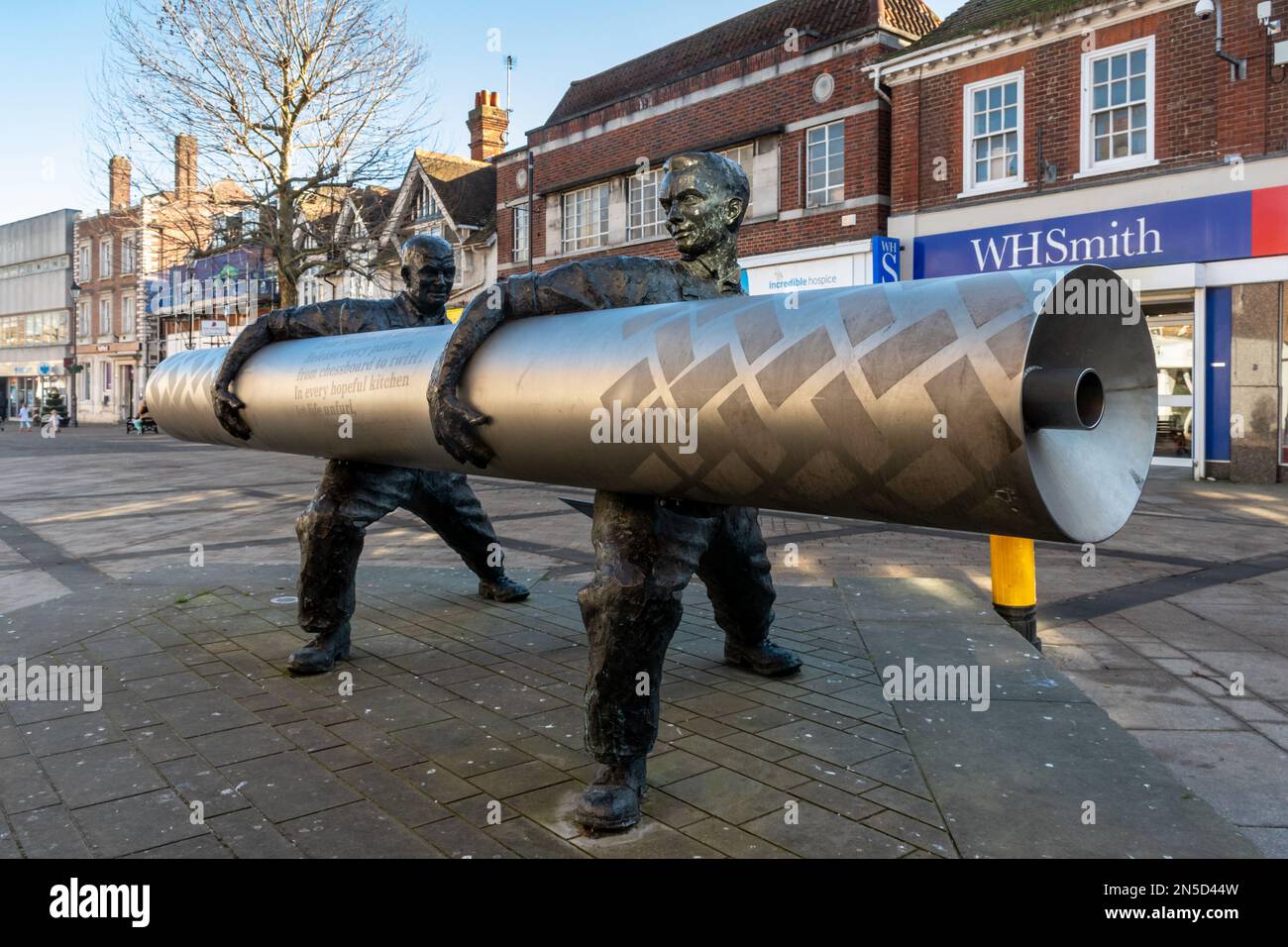 David Annand sculpture of two men carrying a roll of lino, called Roll out the Lino, Staines-upon-Thames High Street, Surrey, UK Stock Photo